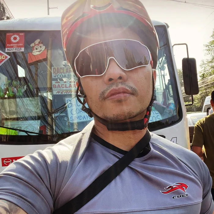 Yong in a cycling helmet and sunglasses, mid-ride